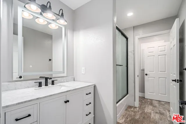 a bathroom with a sink a light fixture and a mirror
