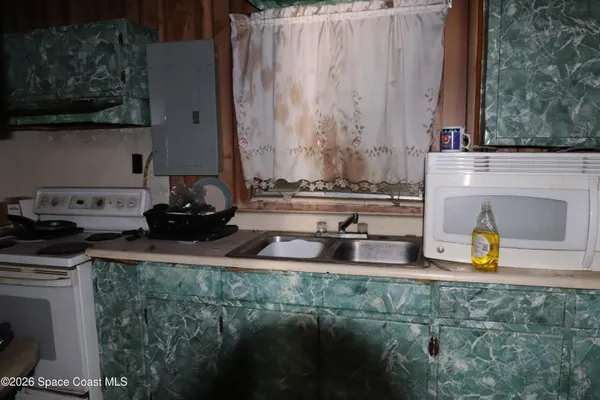 a kitchen with a sink a stove and cabinets