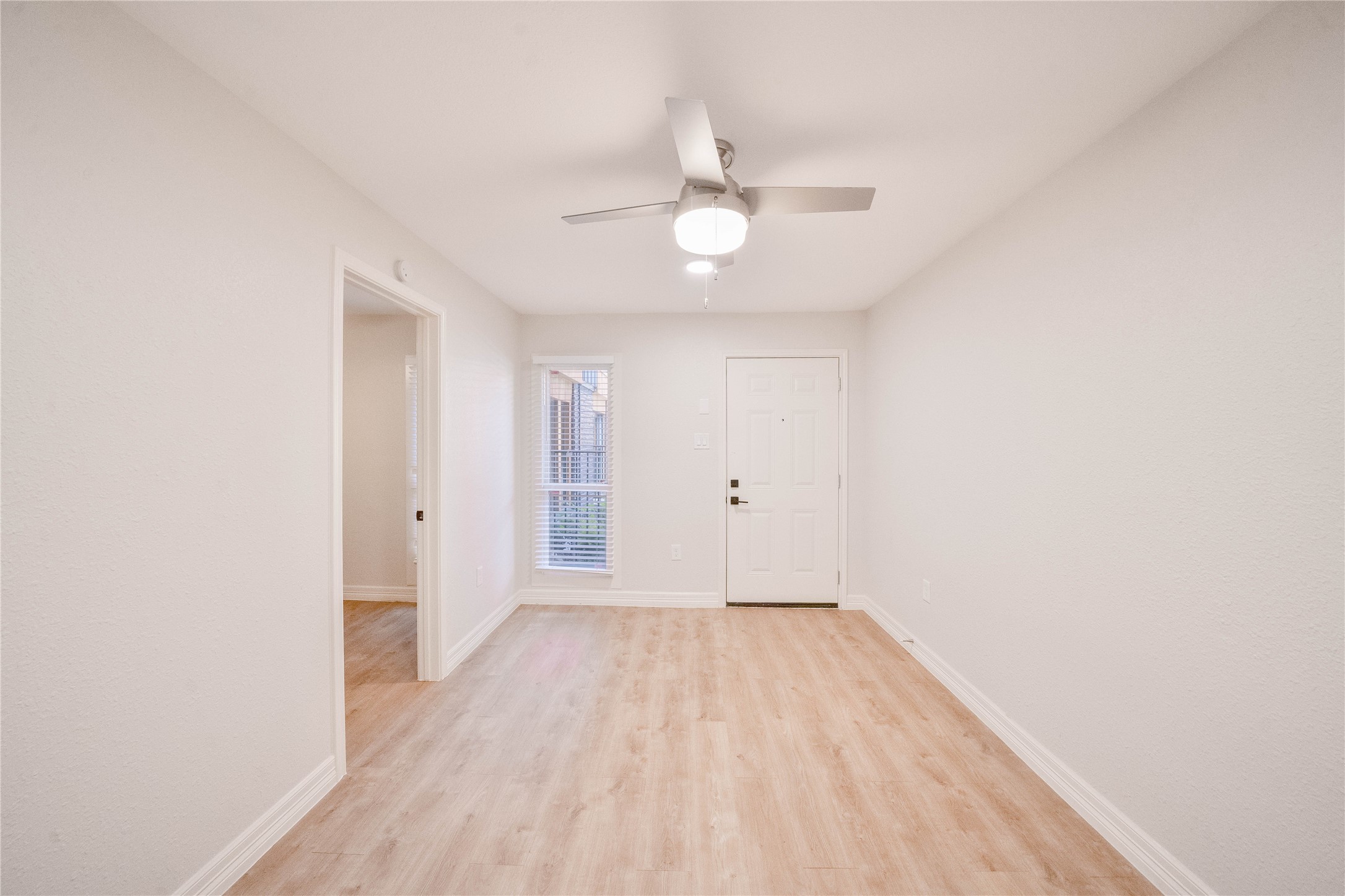 2703 Mason Street, Unit 1BD Houston, TX 77006 - Photo 5 of 19 an empty room with wooden floor and fan