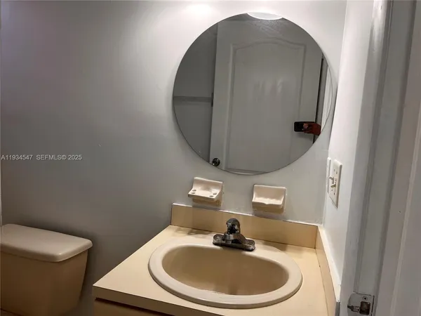 a bathroom with a toilet sink and mirror