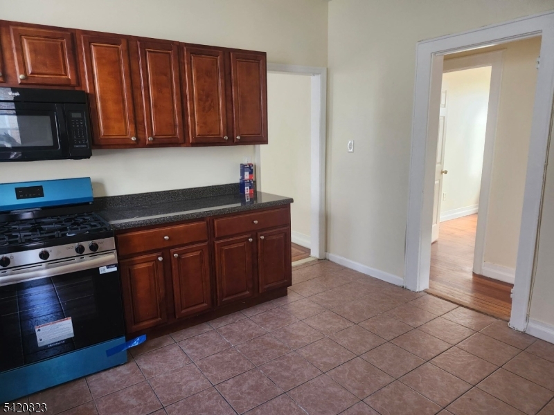313 Leslie Street Newark, NJ 07112 - Photo 2 of 7 a kitchen with stainless steel appliances granite countertop a stove a microwave and a refrigerator