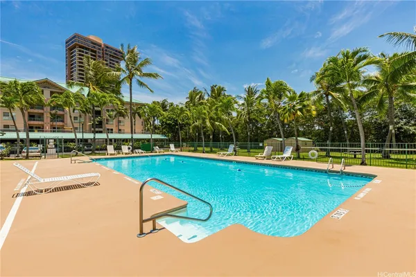 a view of a swimming pool with a lawn chairs under an umbrella