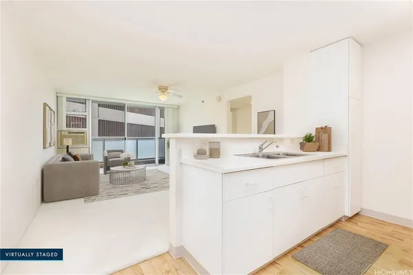 a living room with stainless steel appliances kitchen island granite countertop a sink and cabinets