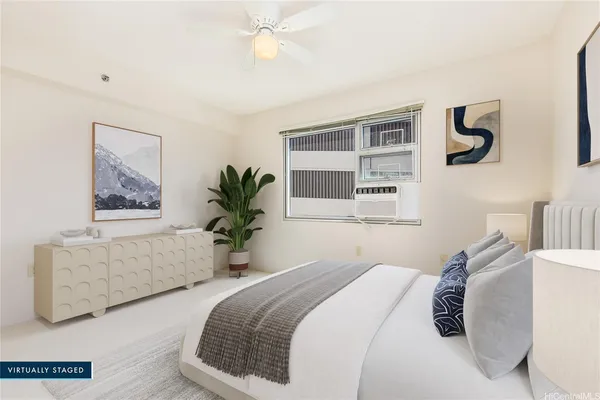 a bedroom with a large bed and ceiling fan