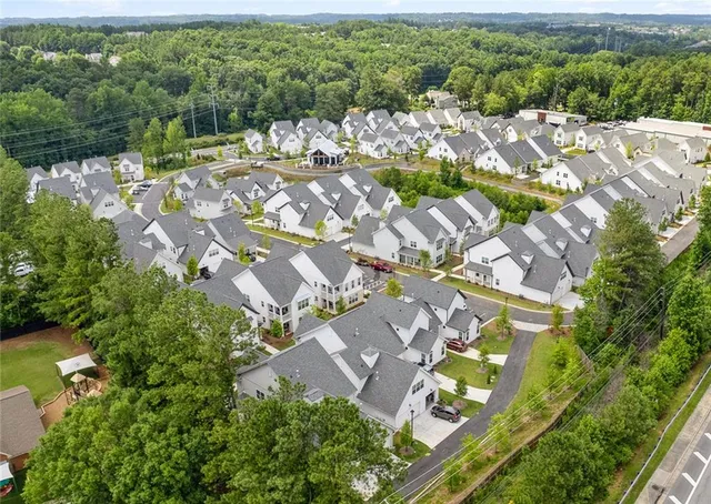 an aerial view of residential houses with outdoor space and trees