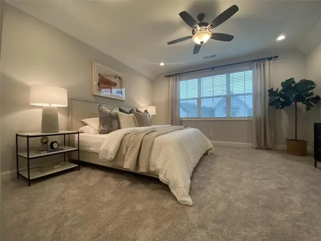 a spacious bedroom with a bed and a chandelier