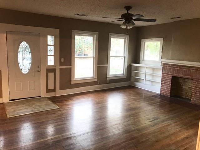 106 West Decatur Street Ennis, TX 75119 - Photo 13 of 17 an empty room with wooden floor chandelier and windows