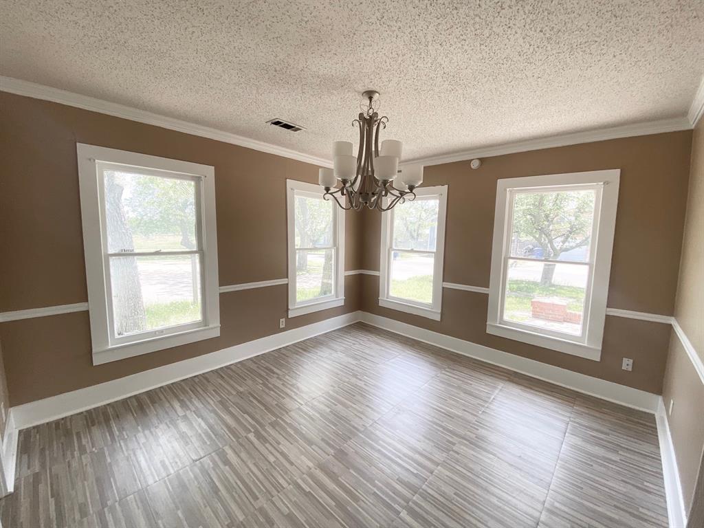 106 West Decatur Street Ennis, TX 75119 - Photo 2 of 17 an empty room with wooden floor and windows