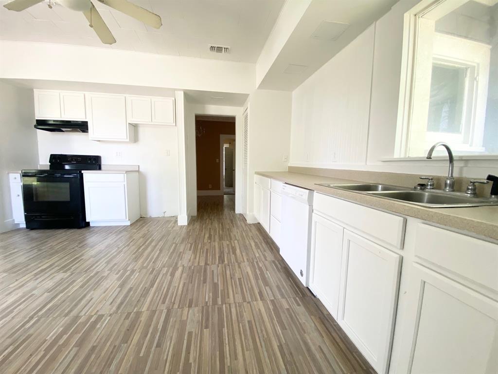 106 West Decatur Street Ennis, TX 75119 - Photo 3 of 17 a kitchen with a sink and wooden floor