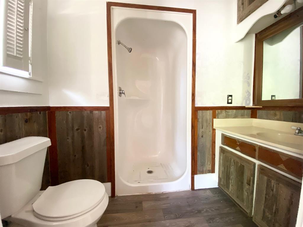 106 West Decatur Street Ennis, TX 75119 - Photo 8 of 17 a bathroom with a toilet a sink and a mirror