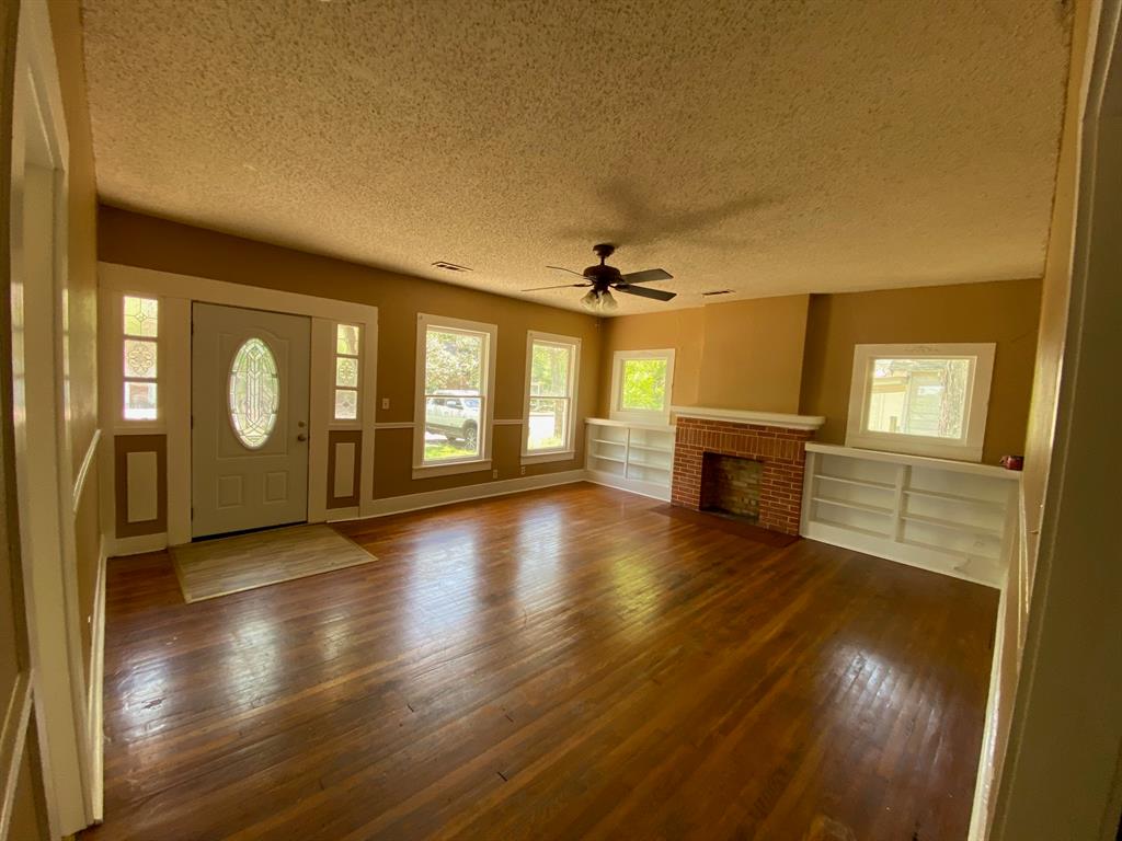 106 West Decatur Street Ennis, TX 75119 - Photo 9 of 17 a view of an empty room with window and wooden floor