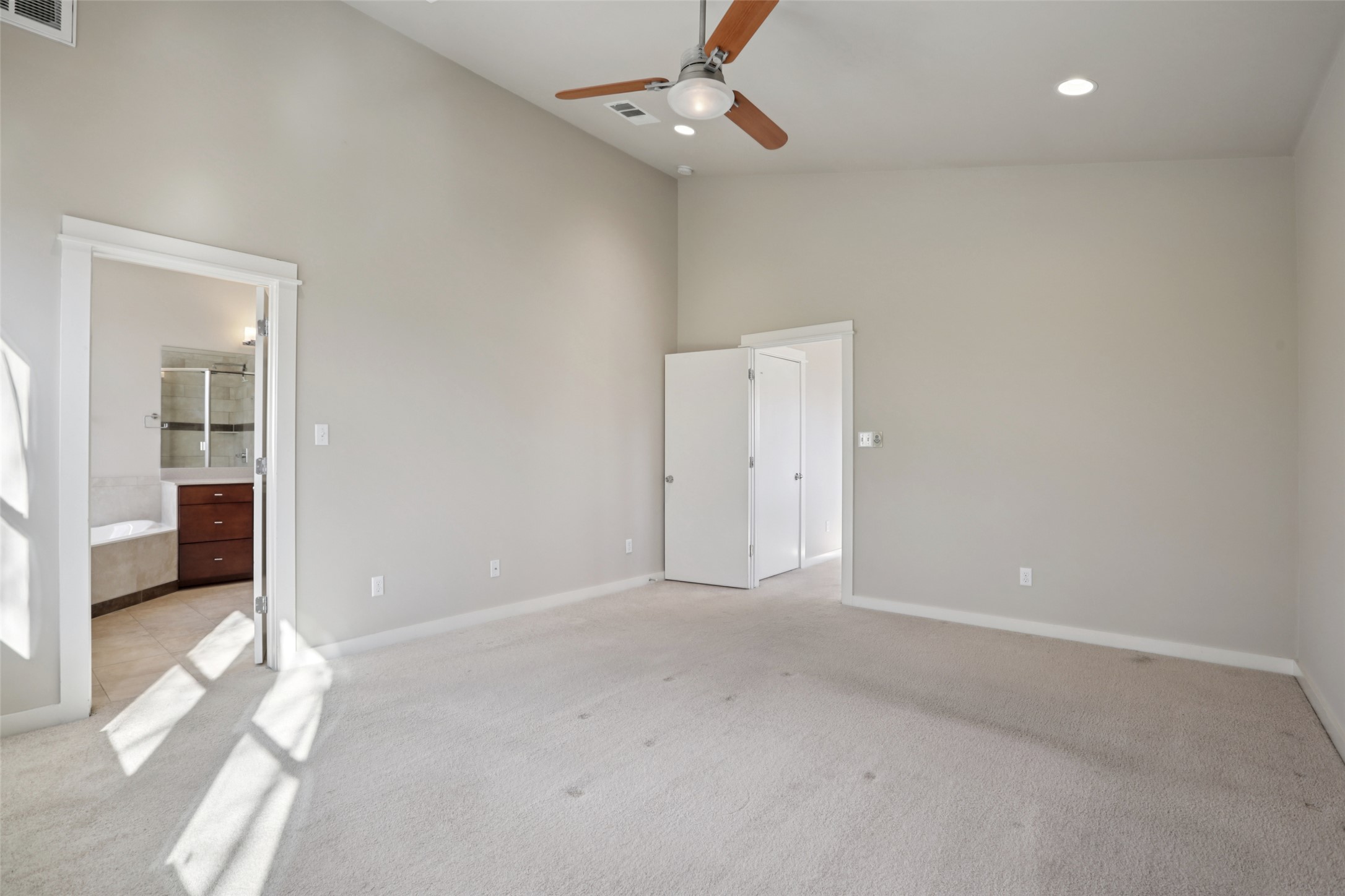 1123 Blair Way Austin, TX 78704 - Photo 19 of 30 Unfurnished bedroom featuring high vaulted ceiling, light carpet, connected bathroom, ceiling fan, and recessed lighting