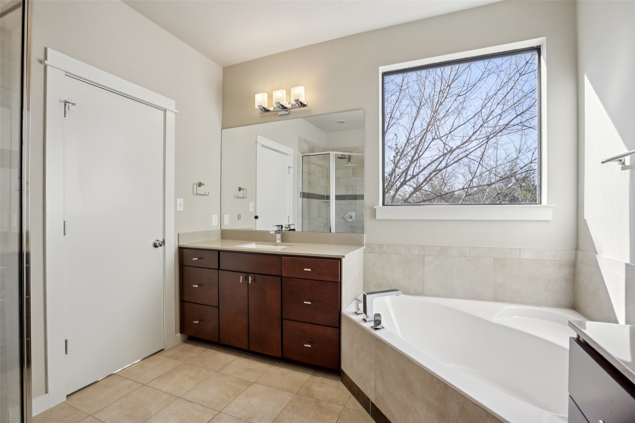 1123 Blair Way Austin, TX 78704 - Photo 24 of 30 Bathroom with vanity, a garden tub, a stall shower, and light tile patterned flooring