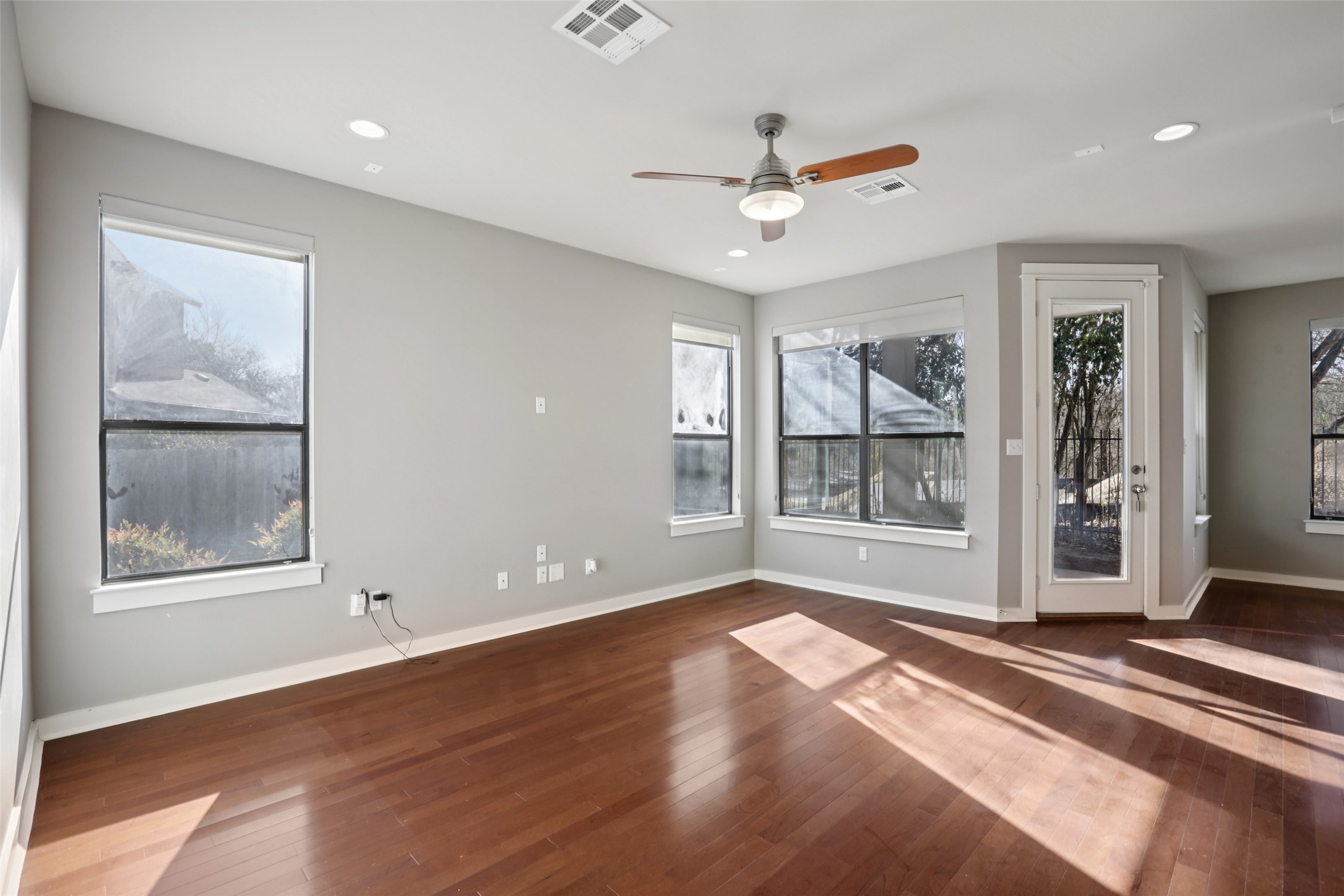 1123 Blair Way Austin, TX 78704 - Photo 6 of 30 Empty room with dark wood-style flooring, healthy amount of natural light, ceiling fan, and recessed lighting