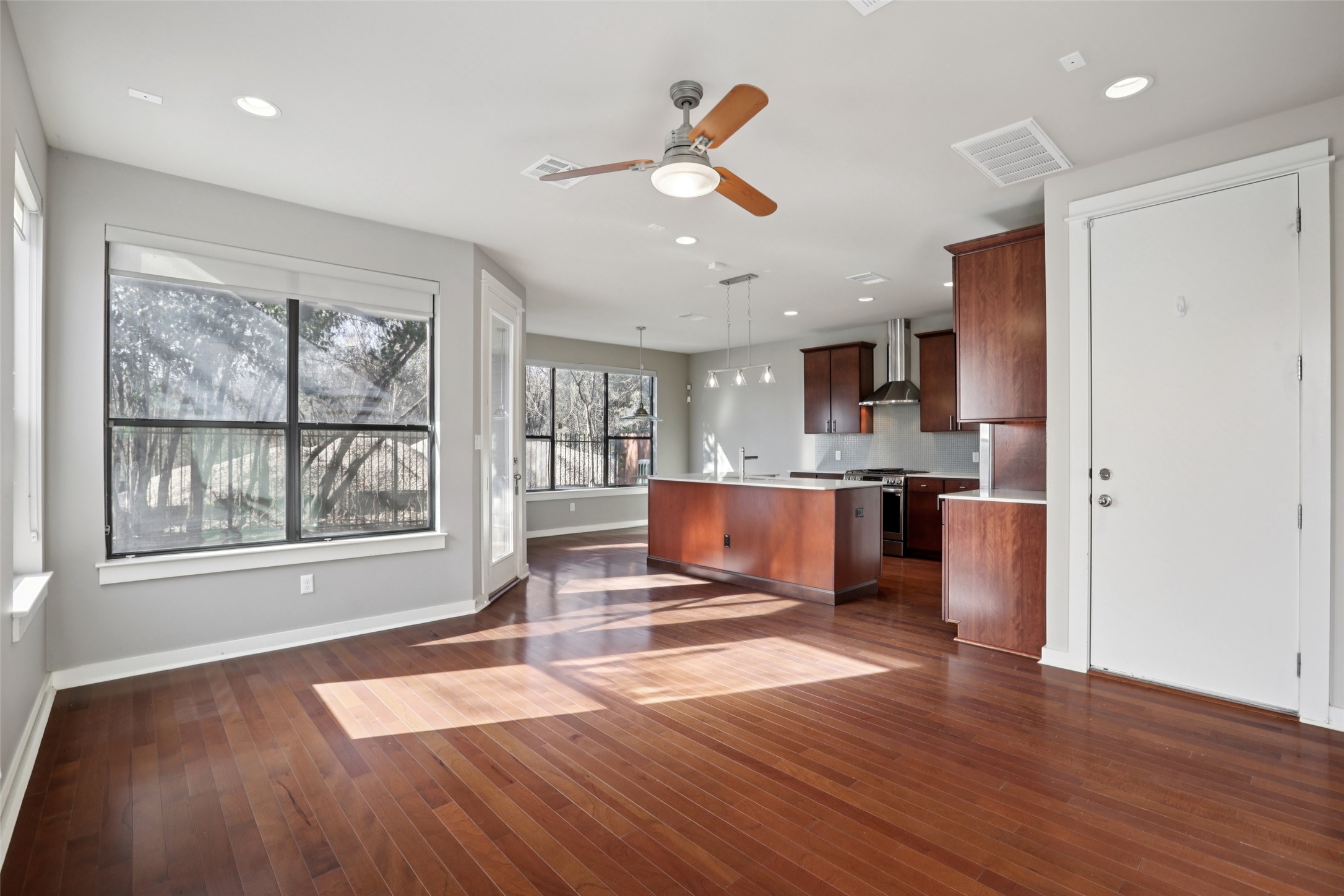 1123 Blair Way Austin, TX 78704 - Photo 28 of 30 Kitchen with open floor plan, hanging light fixtures, a center island with sink, ceiling fan, and dark wood finished floors