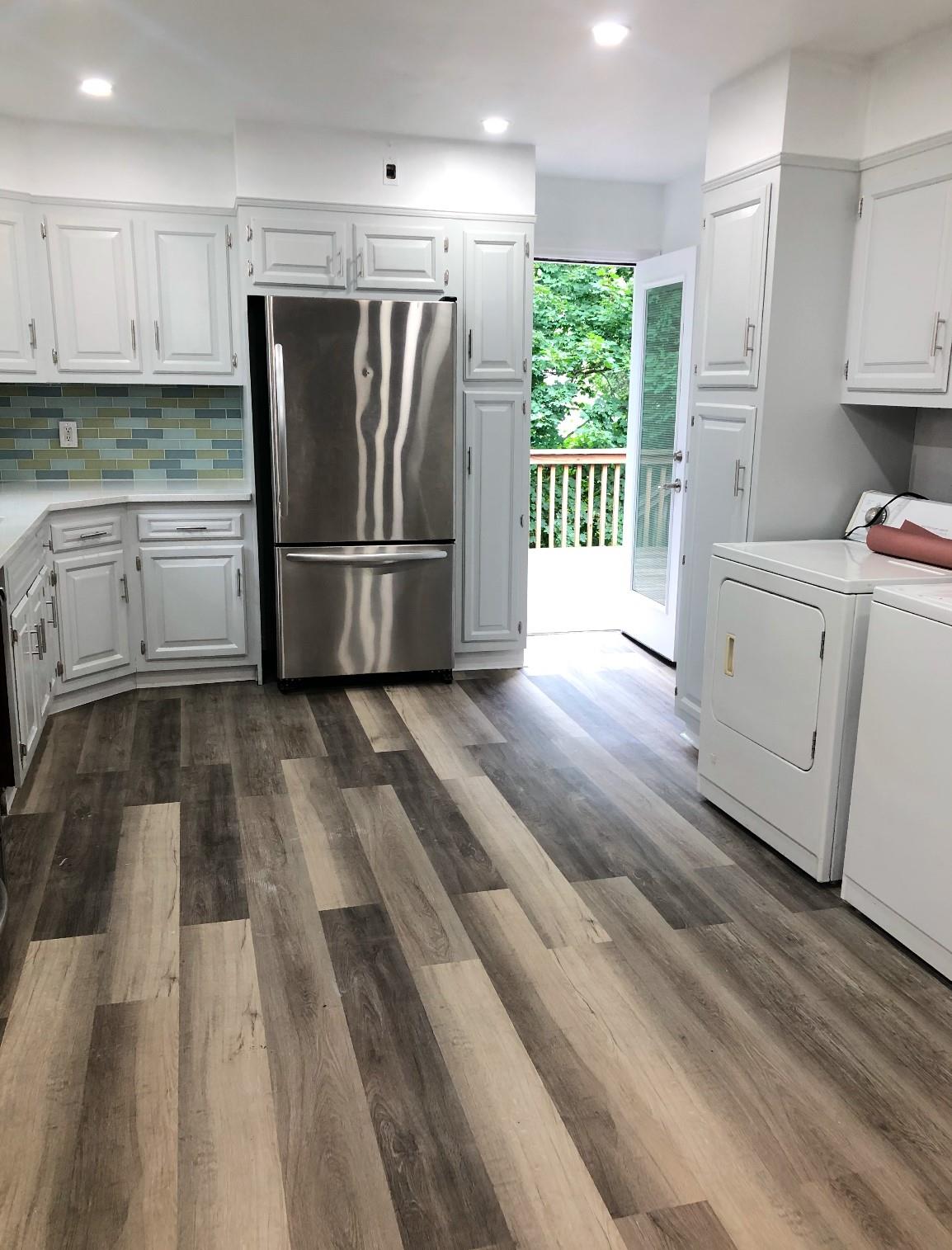 2410 Boston Post Road Larchmont, NY 10538 - Photo 4 of 26 Kitchen featuring washer and clothes dryer, stainless steel fridge, backsplash, dark hardwood / wood-style flooring, and white cabinets