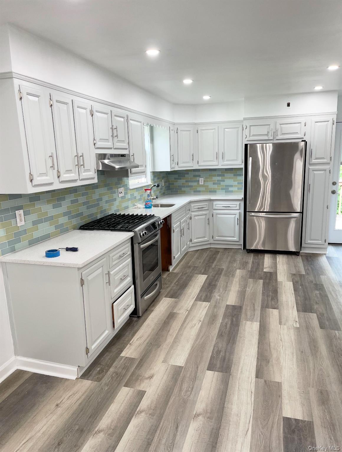 2410 Boston Post Road Larchmont, NY 10538 - Photo 9 of 30 a kitchen with white cabinets sink and stainless steel appliances