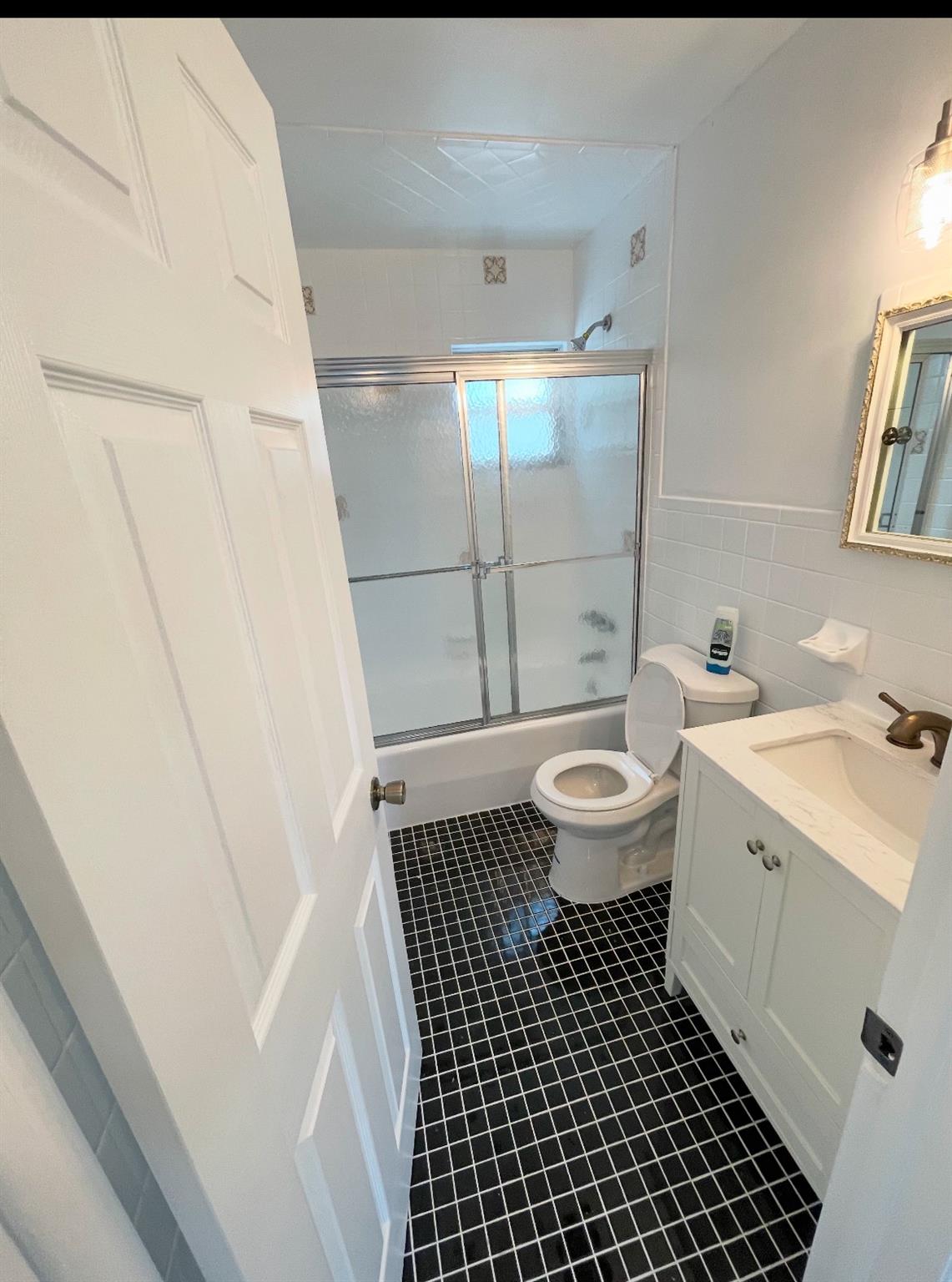 2410 Boston Post Road Larchmont, NY 10538 - Photo 10 of 26 Full bathroom featuring bath / shower combo with glass door, toilet, vanity, and tile patterned flooring