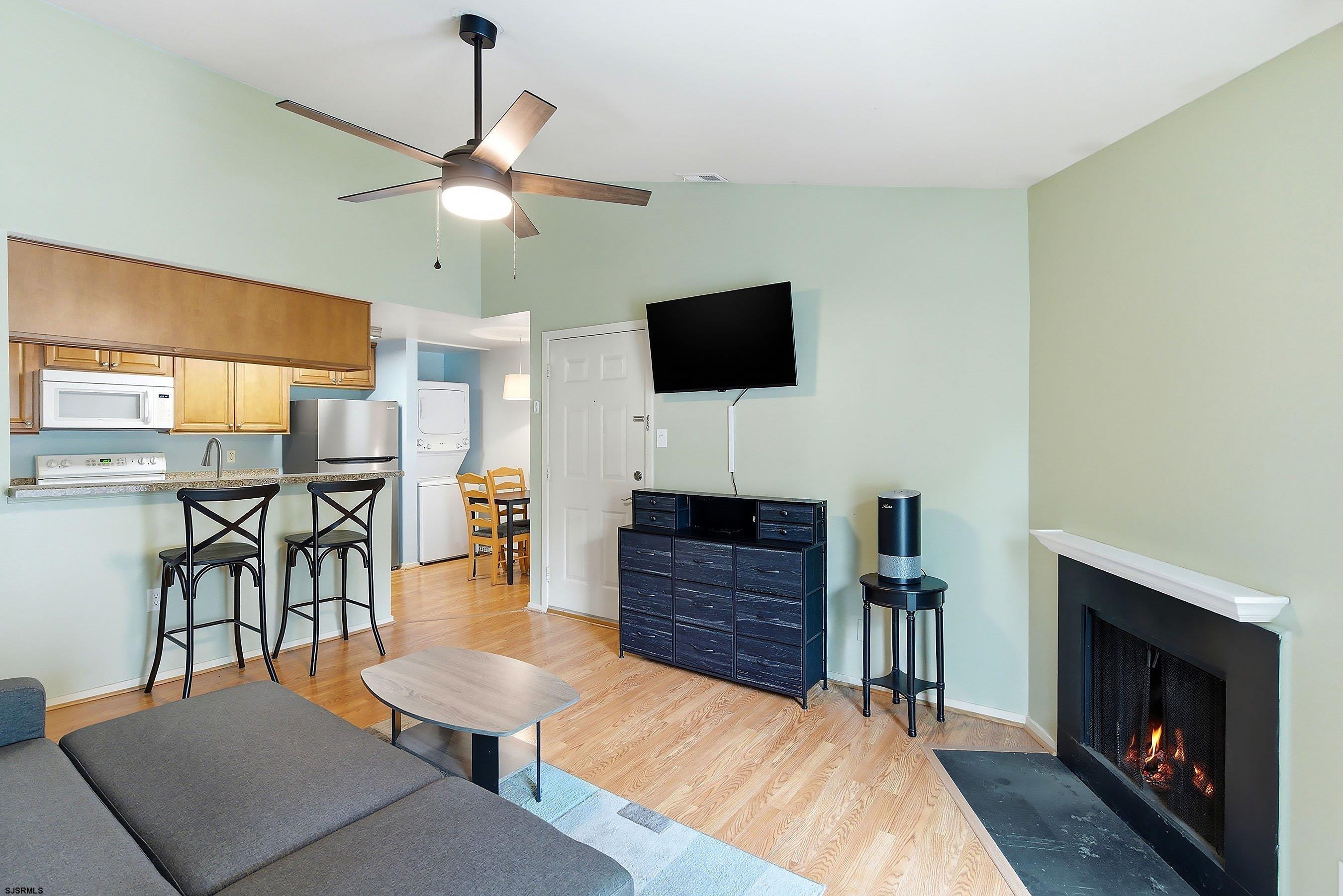 224 Meadow Ridge Road, Unit 224 Smithville, NJ 08205 - Photo 7 of 22 a living room with furniture a fireplace and a flat screen tv
