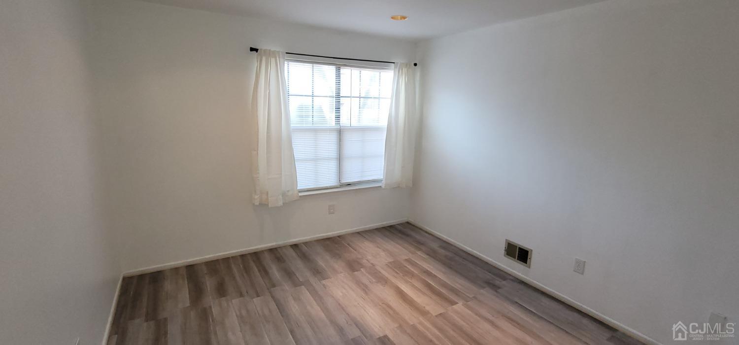 40 Boulder Drive Edison, NJ 08817 - Photo 17 of 23 an empty room with wooden floor and windows