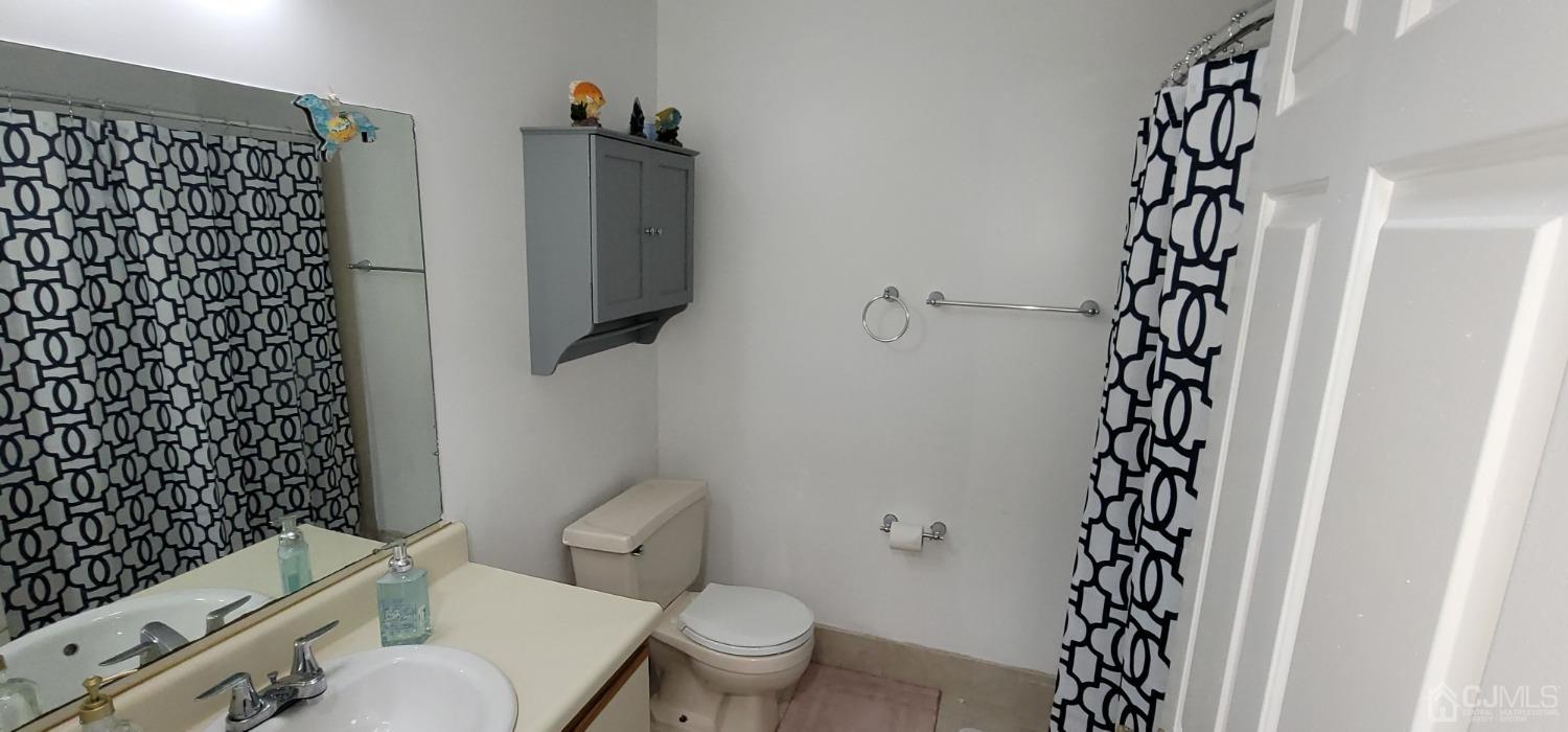 40 Boulder Drive Edison, NJ 08817 - Photo 18 of 23 a bathroom with a toilet and a shower curtain