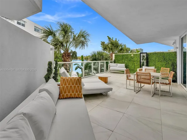 a view of a patio with a dining table and chairs under an umbrella