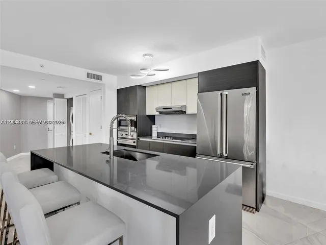 a kitchen with stainless steel appliances granite countertop a refrigerator a sink and a stove