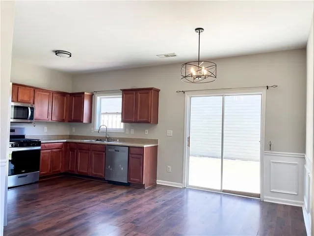 a kitchen with stainless steel appliances granite countertop cabinets and wooden floor