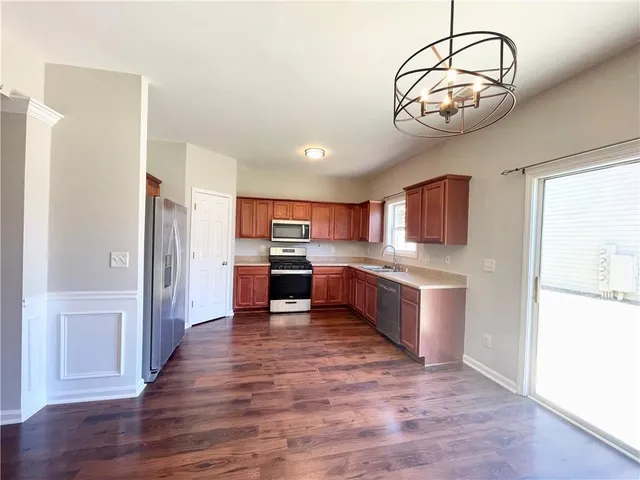 a large kitchen with a large window and stainless steel appliances