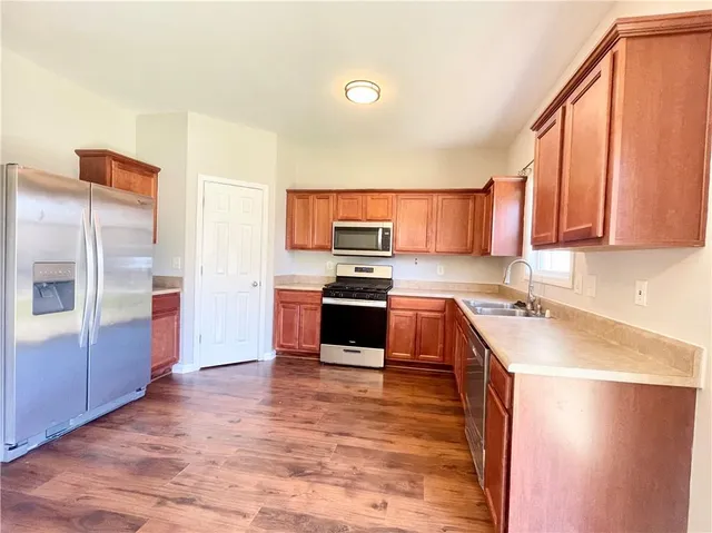 a kitchen with stainless steel appliances a refrigerator sink and microwave