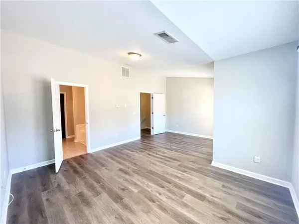 a view of empty room with wooden floor