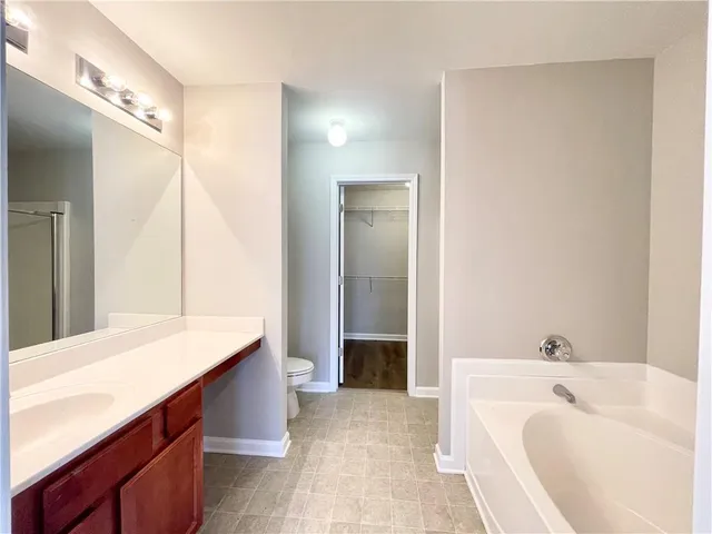 a bathroom with a tub sink and mirror