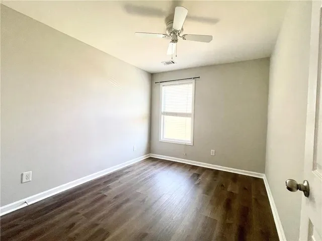 a view of an empty room with wooden floor