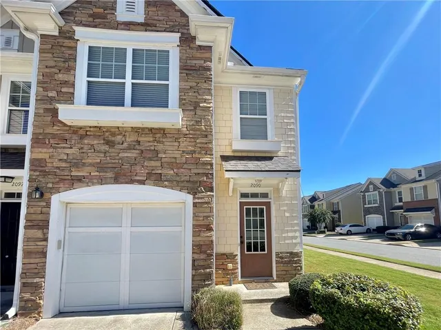 a front view of a house with a garden and yard