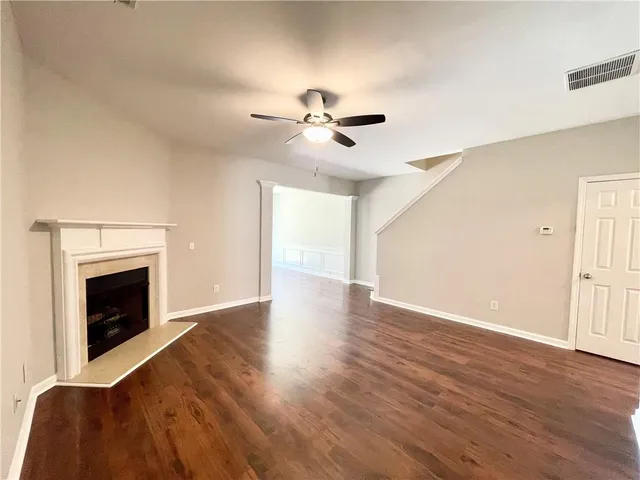 a view of empty room with wooden floor and fireplace