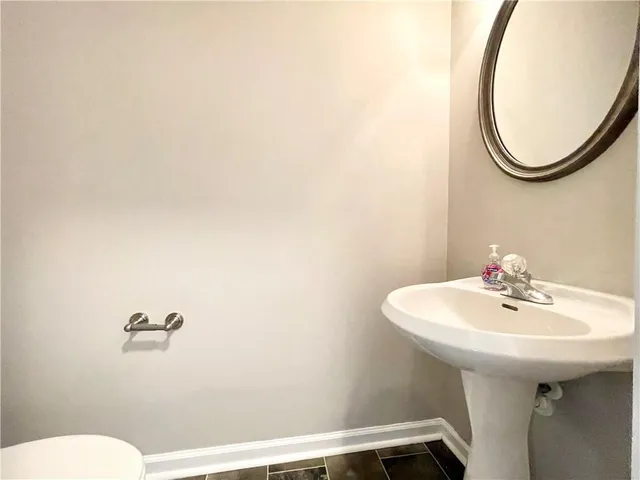 a bathroom with a sink a toilet and mirror