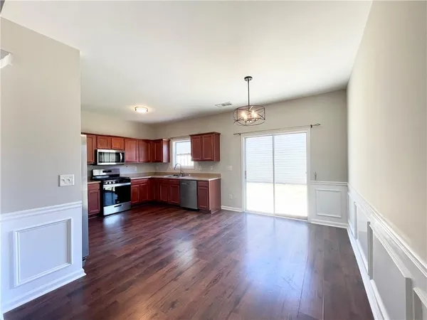 a living room with stainless steel appliances kitchen island hard wood floors and fireplace