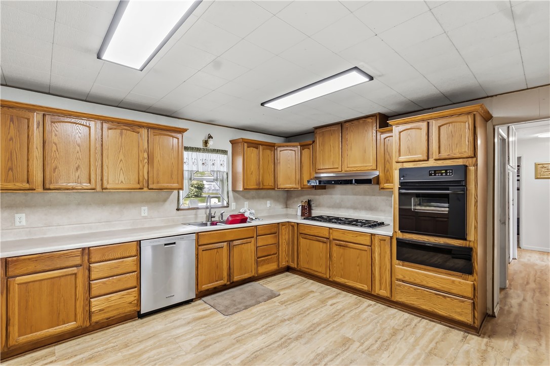 10084 Fm 831 Buffalo, TX 75831 - Photo 15 of 50 a kitchen with stainless steel appliances granite countertop wooden cabinets a sink a stove a refrigerator with grey cabinets and wooden floor