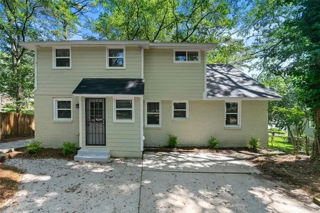 a view of a small house with a yard