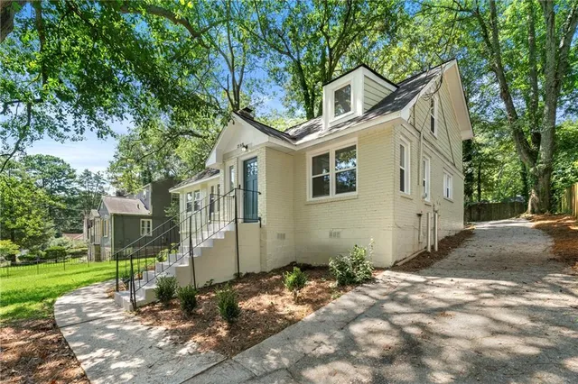 a front view of a house with a yard and trees