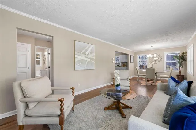 a living room with furniture couches and a dining table with wooden floor