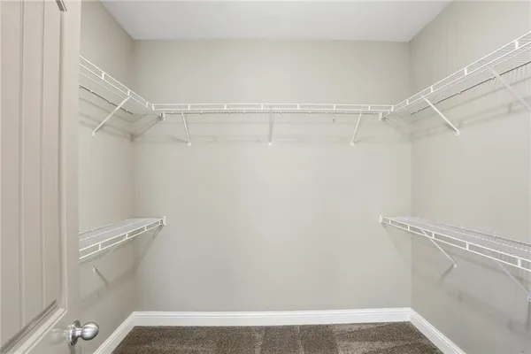 a view of walk in closet with empty racks