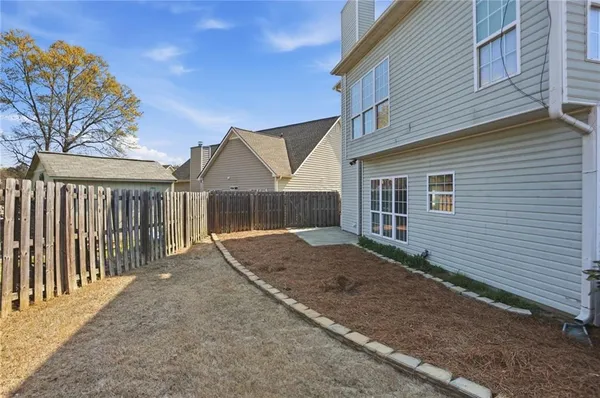 a view of a house with a yard and wooden fence