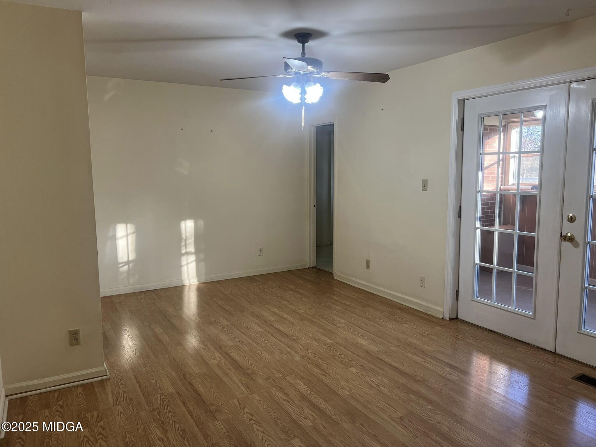3640 South Walden Road Macon, GA 31216 - Photo 12 of 21 a view of an empty room with wooden floor and a window