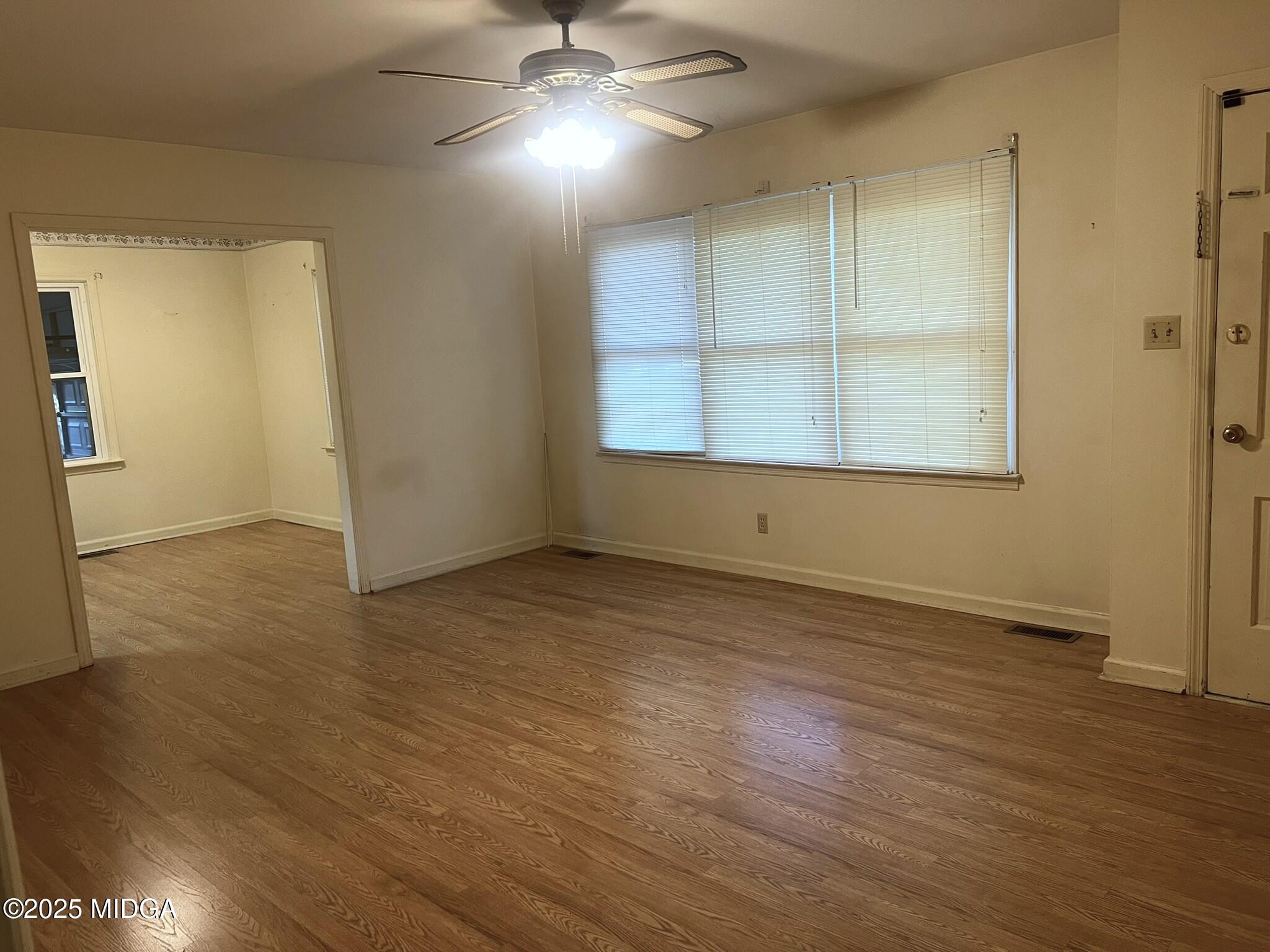 3640 South Walden Road Macon, GA 31216 - Photo 8 of 21 an empty room with wooden floor cabinet and windows