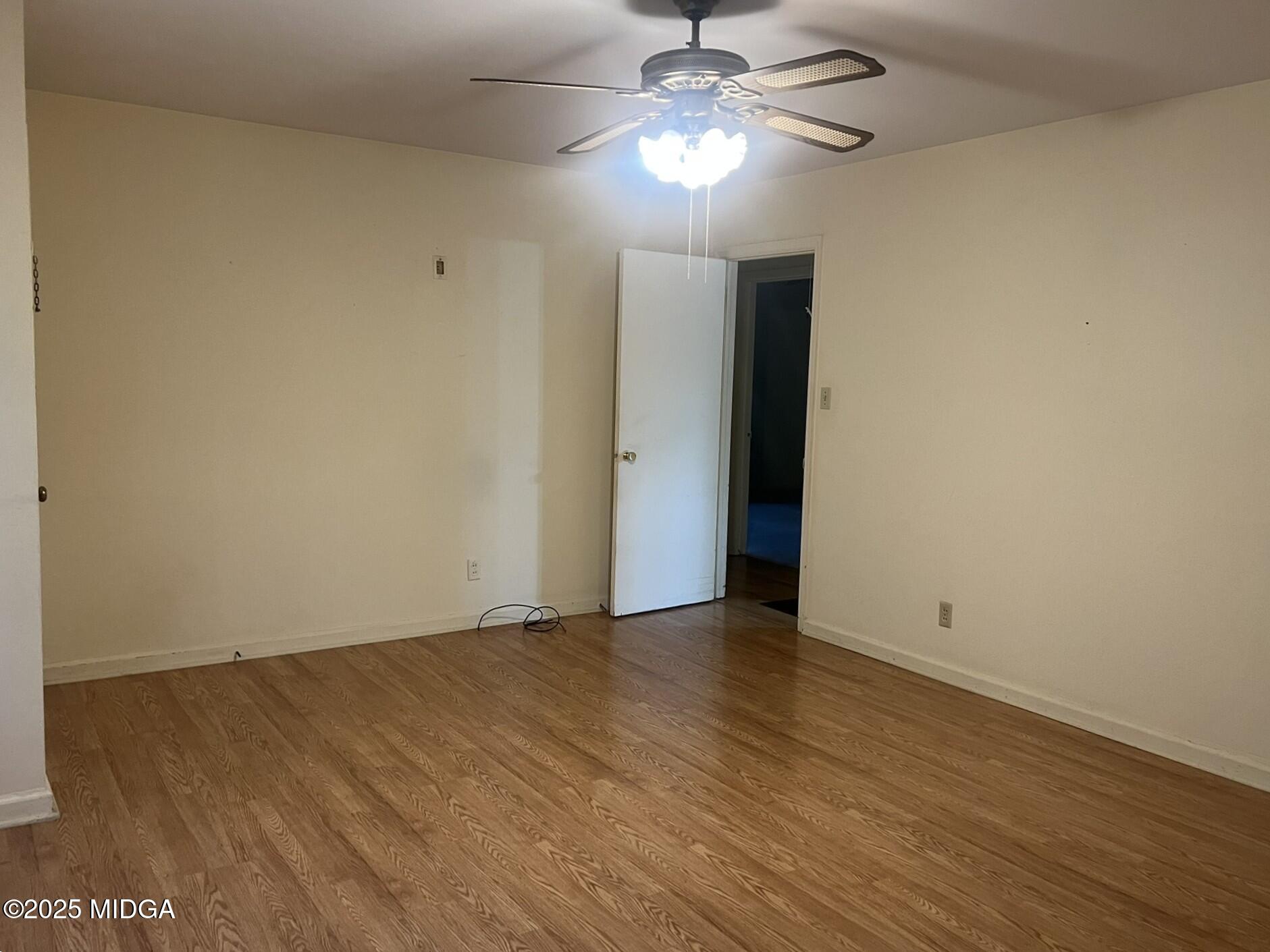 3640 South Walden Road Macon, GA 31216 - Photo 9 of 21 an empty room with wooden floor chandelier fan and closet area