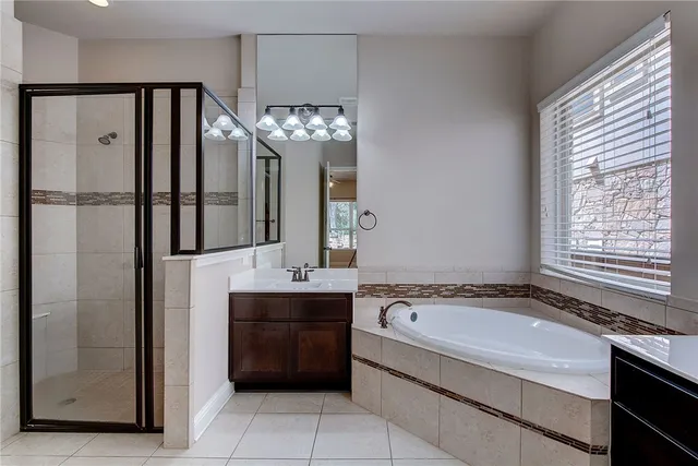 a bathroom with a tub sink and mirror