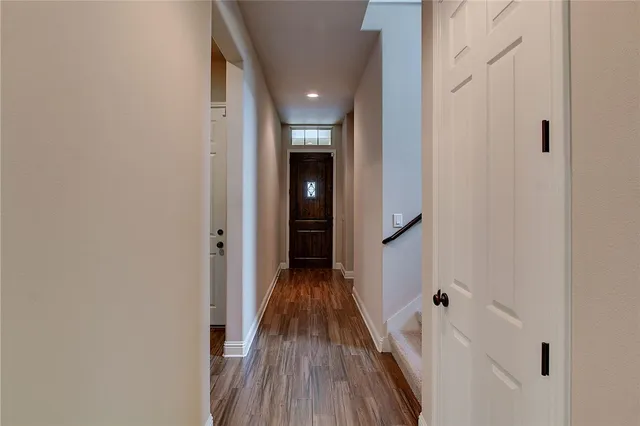 a view of a hallway with wooden floor and staircase