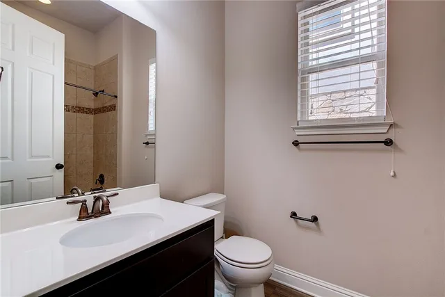 a bathroom with a sink vanity mirror and toilet