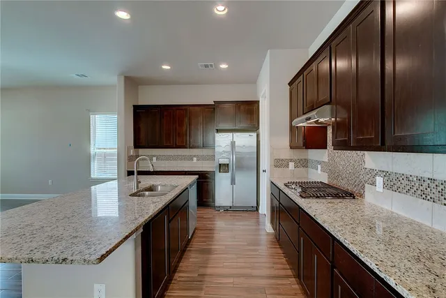 a kitchen with stainless steel appliances granite countertop sink stove microwave and cabinets